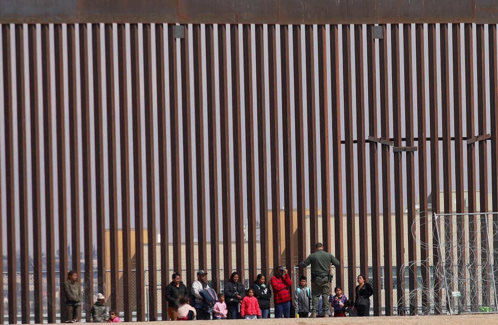 Texas National Guard agents process migrants who crossed the El Paso border and the Rio Grande river from Ciudad Juarez, Mexico.