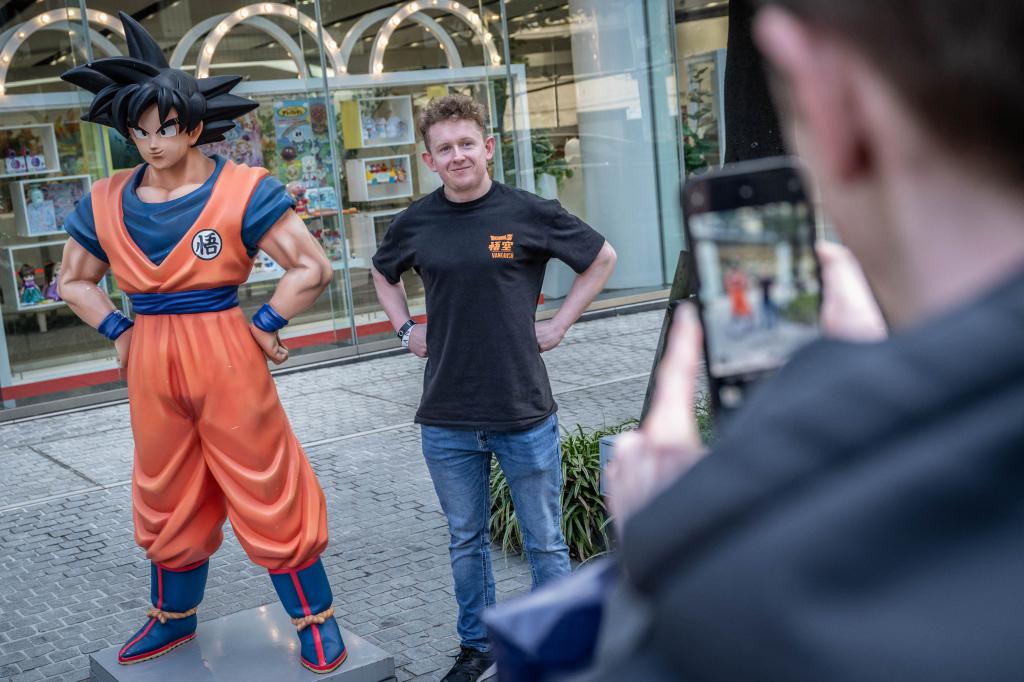 A fan takes a picture next to a statue of Dragon Ball character "Son Goku" in Tokyo on March 8, 2024.
