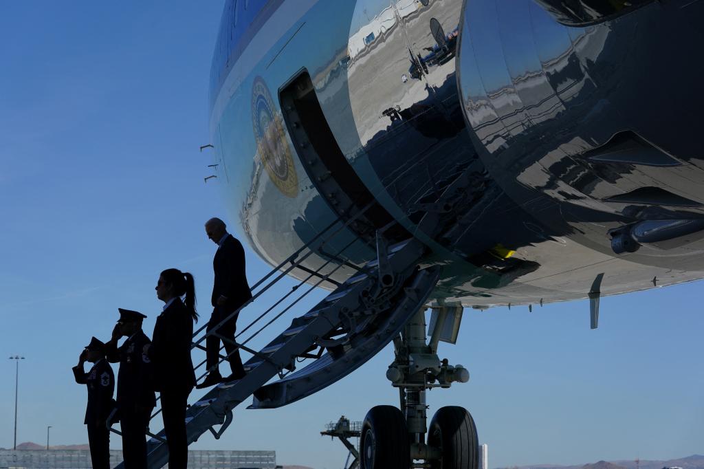President Biden exits Air Force One, in silhouette.