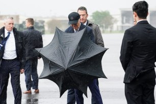 President Joe Biden opens an umbrella, as he arrives in Houston, Texas, U.S., March 21, 2024.