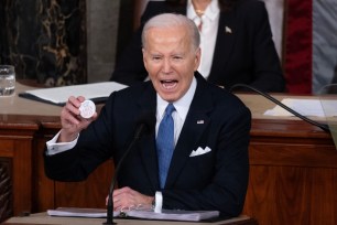 US President Joe Biden holds a pin referring to slain Georgia student Laken Riley; while delivering his State of the Union address