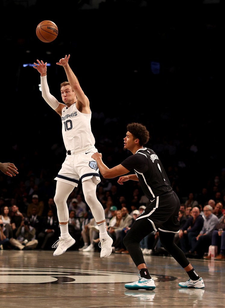 Luke Kennard passes the ball as Cameron Johnson #2 of the Brooklyn Nets defends during the first half.