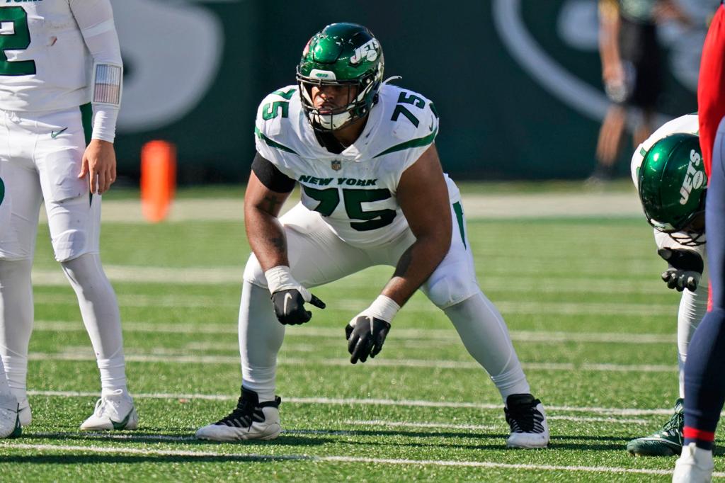 New York Jets' Alijah Vera-Tucker gets set during the second half of an NFL football game New England Patriots, Sept. 19, 2021, in East Rutherford, N.J. Vera-Tucker was taken in the NFL draft 12 spots after Zach Wilson when general manager Joe Douglas traded up to get him. And he has settled in as arguably New York's best offensive lineman this season.