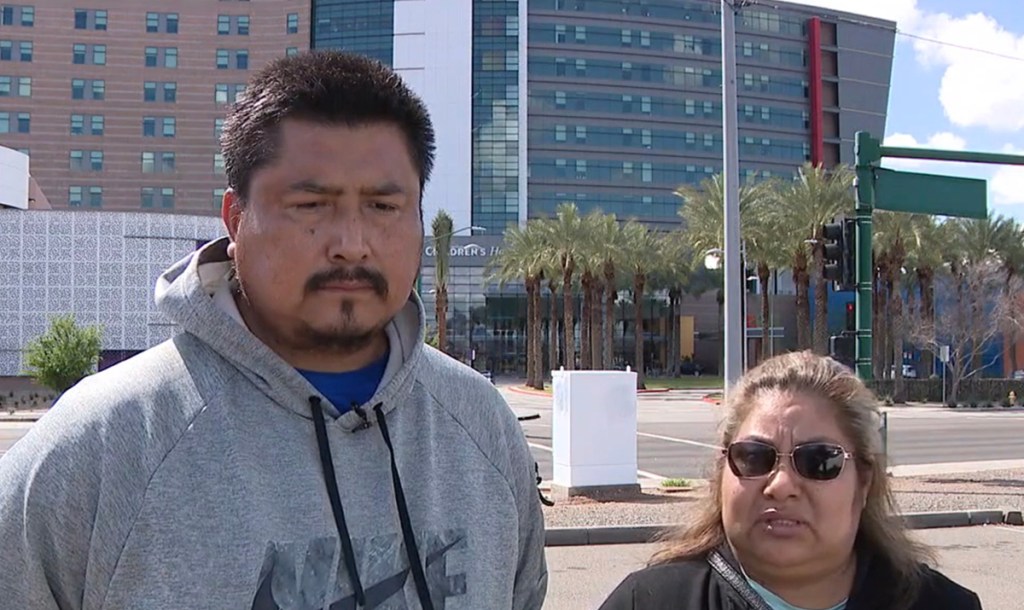 a man and woman standing in front of a building