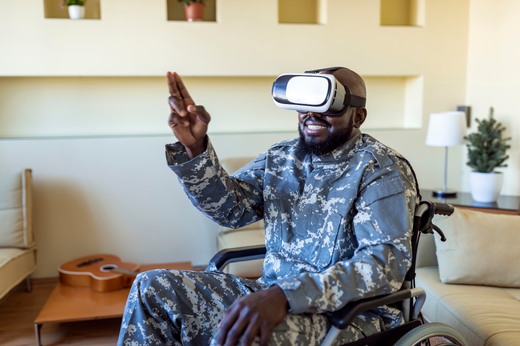 African American male veteran in a wheelchair with VR glasses on.