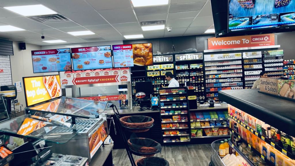 Sahana Kumari inside a Circle K store, featuring a counter and shelves filled with food