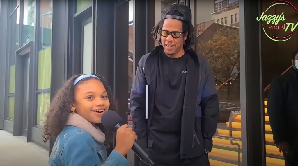 Jay-Z standing next to a young girl, Jazzy, during an interview