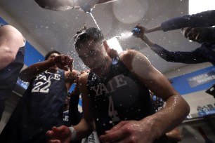 John Poulakidas #4 of the Yale Bulldogs is showered by teammates in the locker room after a 78-76 victory against the Auburn Tigers in the first round of the NCAA Men's Basketball Tournament.