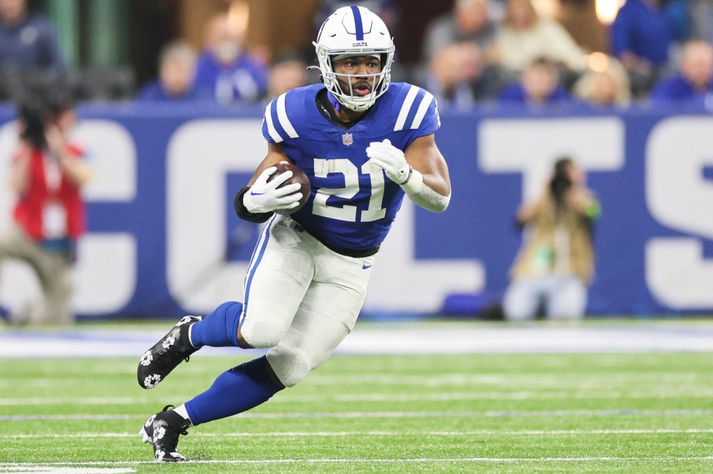 A football player, Zack Moss, running with the ball during a game at Lucas Oil Stadium in Indianapolis.