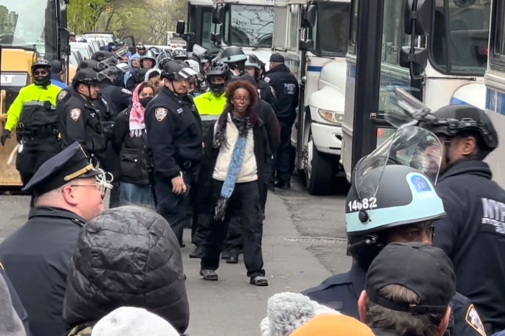 Isra Hirsi, daughter of US Rep. Ilhan Omar, being arrested by NYPD in riot gear during a raid on Columbia University campus with numerous protesters detained in the background