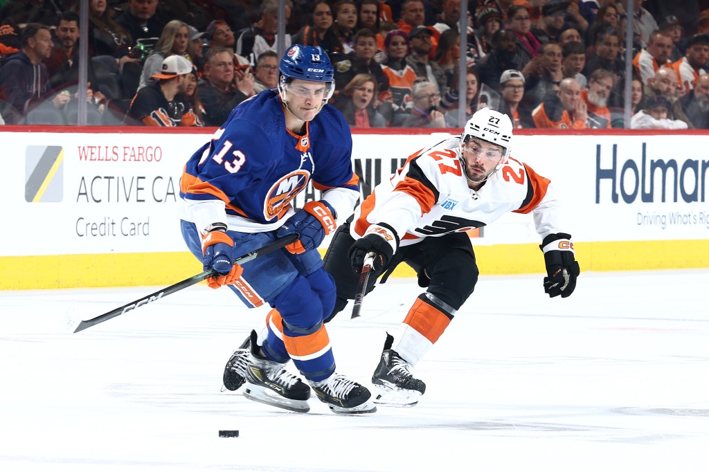 Mathew Barzal #13 of the New York Islanders and Noah Cates #27 of the Philadelphia Flyers challenge for the puck