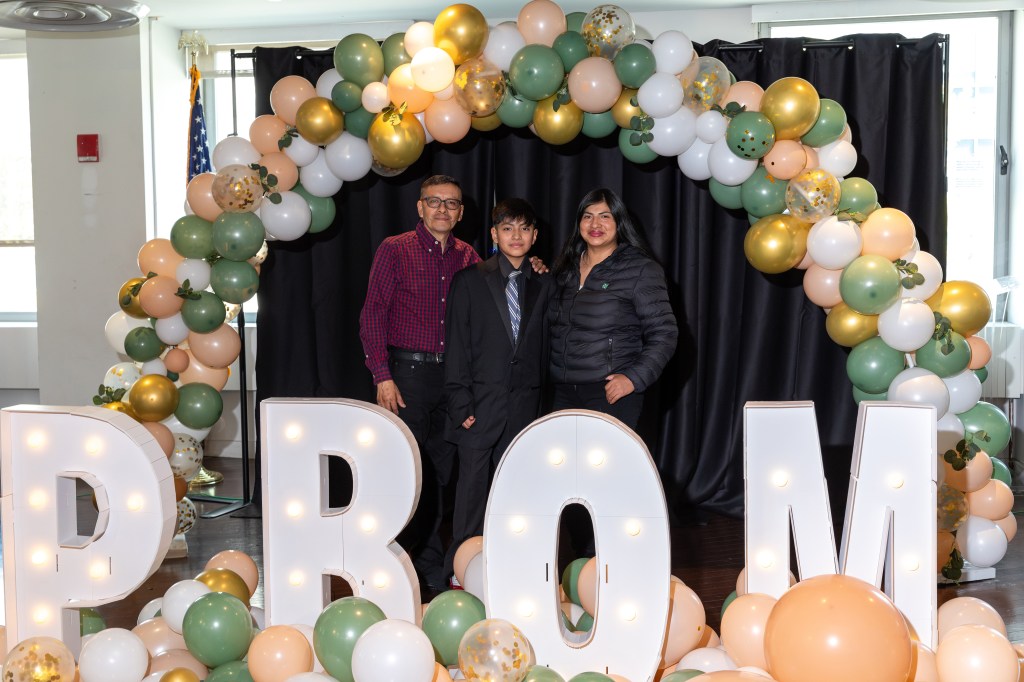 Christopher, 13, seen with parents in front of Prom photo op