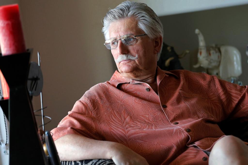 Fred Goldman, father of murder victim Ron Goldman, seated in his home with a mustache and glasses