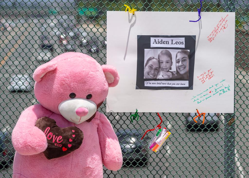 A makeshift memorial photo with a picture of Aiden and a pink teddy bear