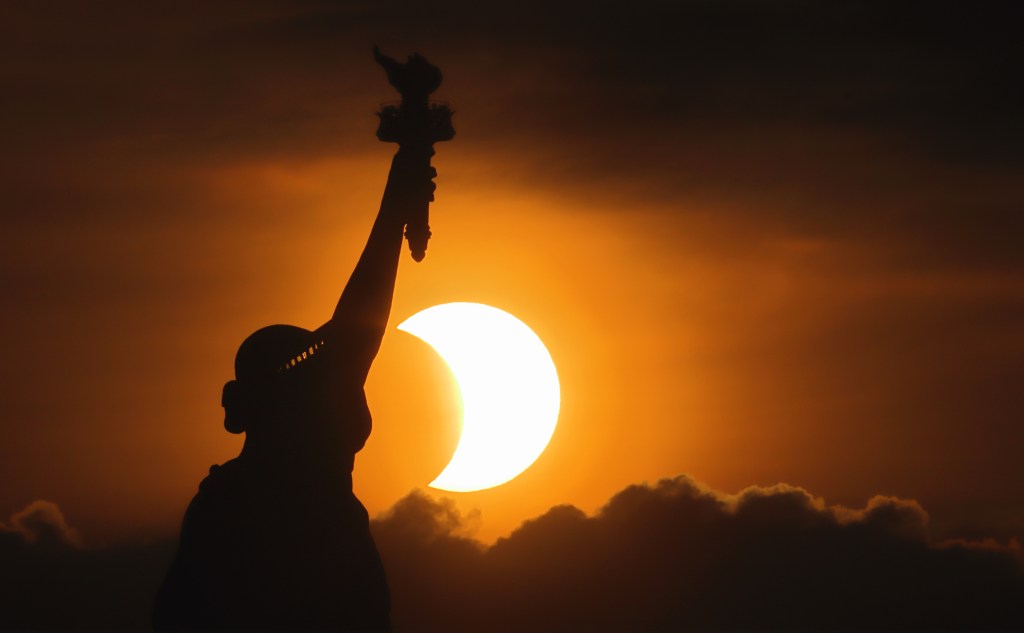 The Statue of Liberty silhouetted against the sun during a rare sunrise eclipse in New York City on June 10, 2021.