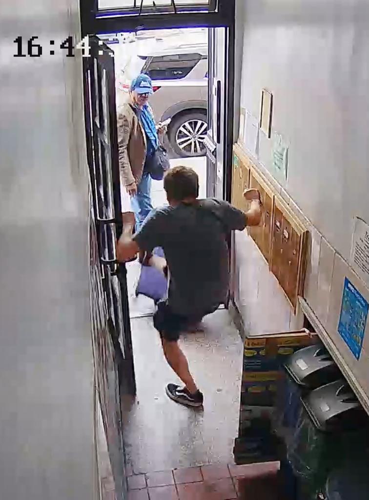 Screen grab of Boucher throwing suitcases out of the Essex Street apartment building with man in the doorway. 
