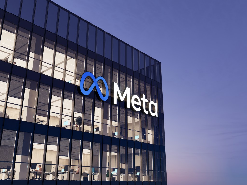 Meta company logo displayed on top of high-rise glass office building in Menlo Park, California.