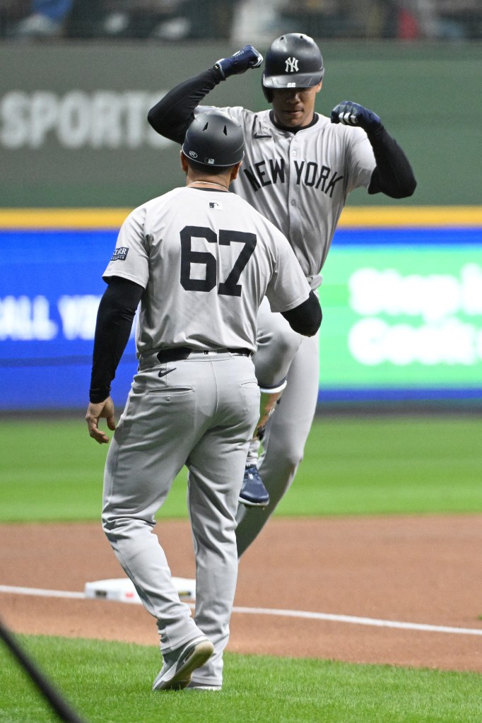 New York Yankees outfielder Juan Soto (22) celebrates with New York Yankees third base coach Luis Rojas (67) after hitting a home run against the Milwaukee Brewers in the first inning at American Family Field.