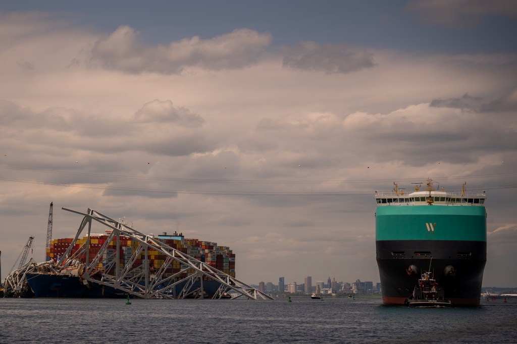 Cargo ship moves past Baltimore Key Bridge wreckage.