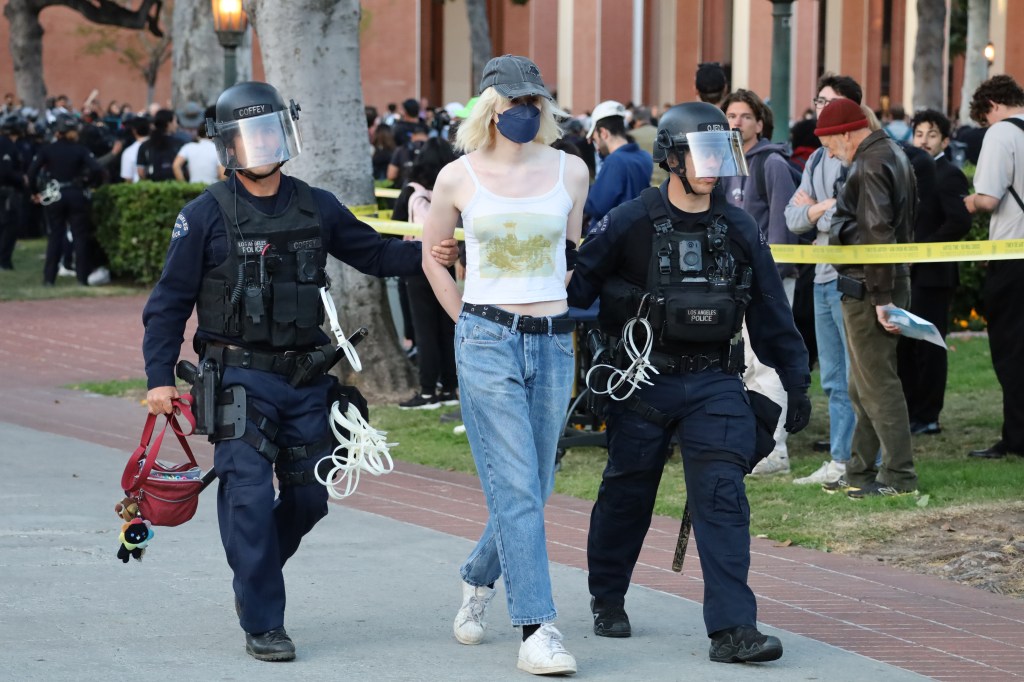 A protestor is detained by police after USC's campus was shut down to a large protest on April 24, 2024.
