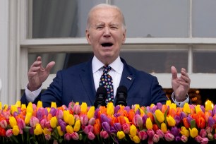 US President Joe Biden speaking at a podium on the Truman balcony of the White House during the 2024 Easter Egg Roll event