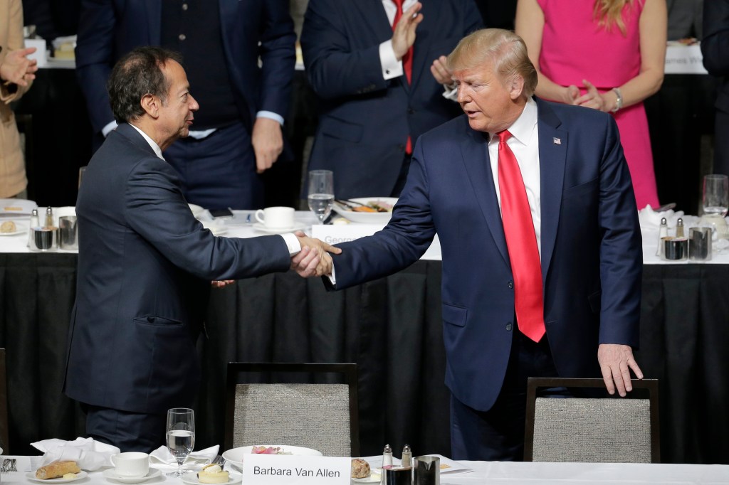President Donald Trump, right, shakes hands with John Paulson