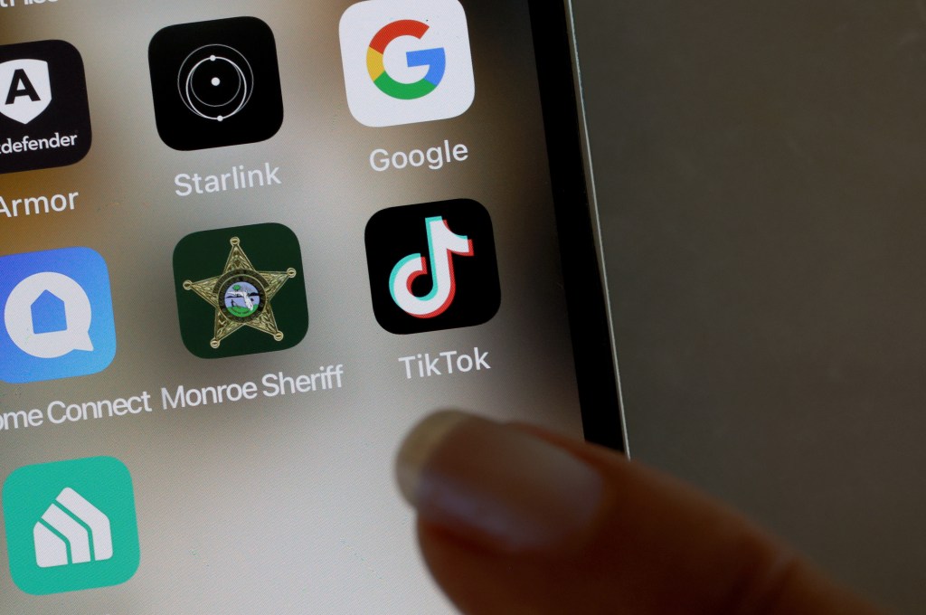 Photo illustration of the TikTok app displayed on an iPhone screen, symbolizing President Joe Biden's bill pushing for its sale to an American company