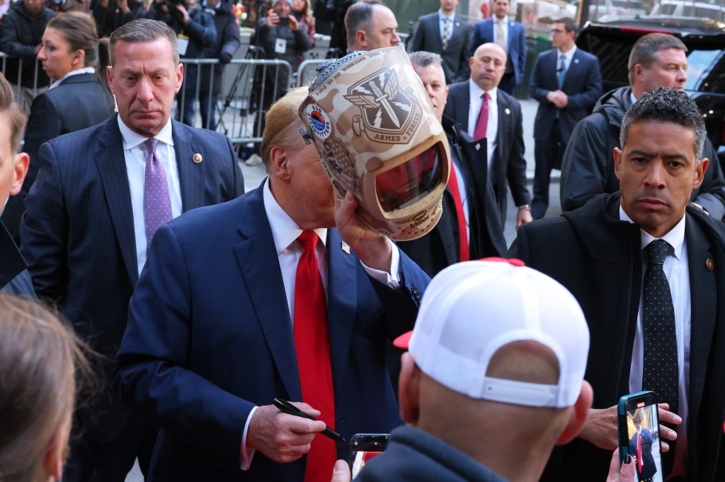 Trump holds up a welder mask during the visit.