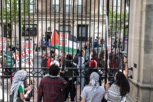Columbia University students participate in a pro-Palestinian protest through a locked gate as they maintain an ongoing pro-Palestinian encampment on their campus on April 23, 2024 in New York City.