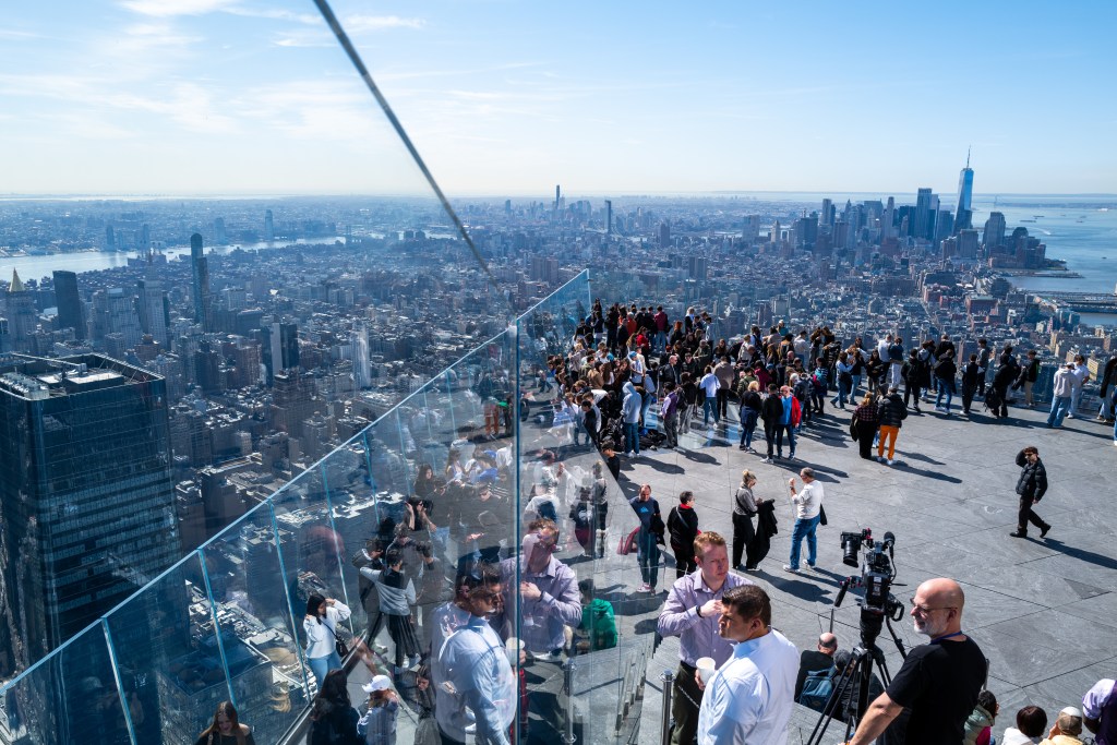 People gather at the Edge overlook in Hudson Yards ahead of the NYC solar eclipse on Monday afternoon