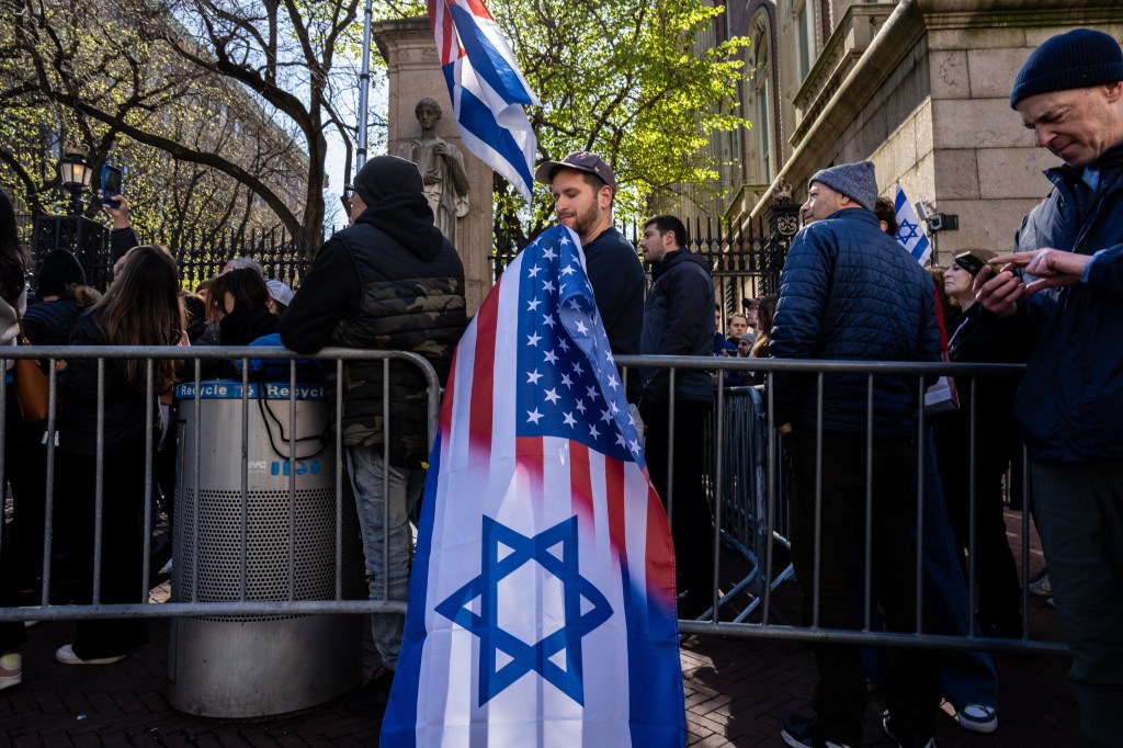 Man holding flag that blends the Israeli and American flag symbols