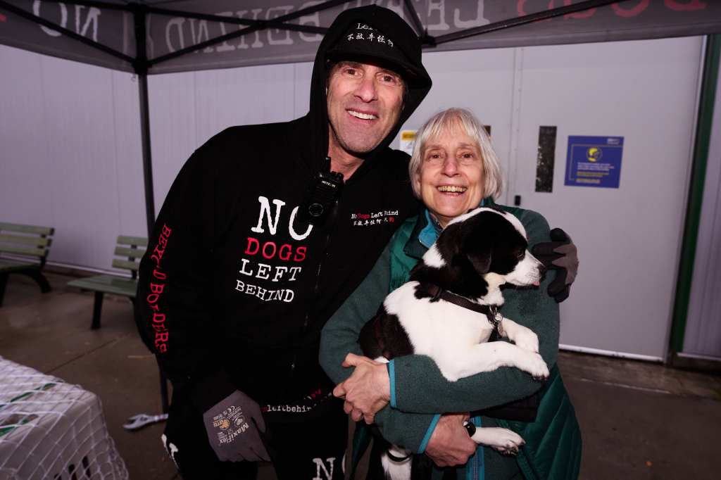 Jeffrey Beri, founder of No Dogs Left Behind, and Joan Downing, of Boston, Mass., with her dog, Theo, who a dog that was saved by No Dogs Left Behind in 2021 as they waited for nearly 50 dogs and cats that were saved from the dog and cat meat trade and arrived at JFK International Airport on Tuesday, April 2, 2024 in Queens.