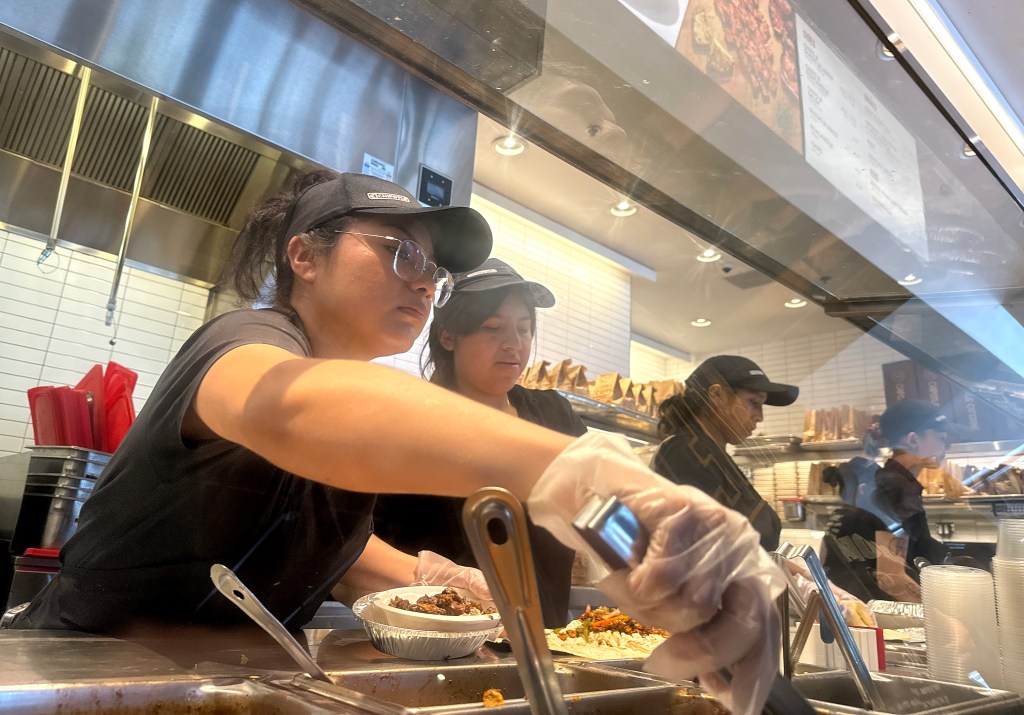 Chipotle workers serve customers at a location in San Rafael, Calif. on Monday -- the day a new $20-an-hour minimum wage law for fast food workers went into effect.