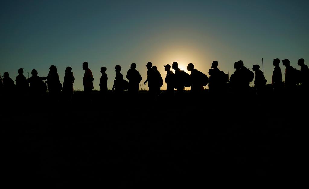 Migrants lined up for processing by U.S. Customs and Border Protection after crossing the Rio Grande from Mexico into Eagle Pass, Texas