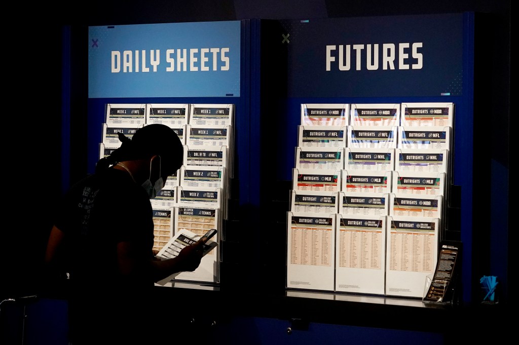 A customer looks over daily sheets inside FanDuel Sportsbook inside Footprint Center, Thursday, Sept. 9, 2021, in Phoenix. 