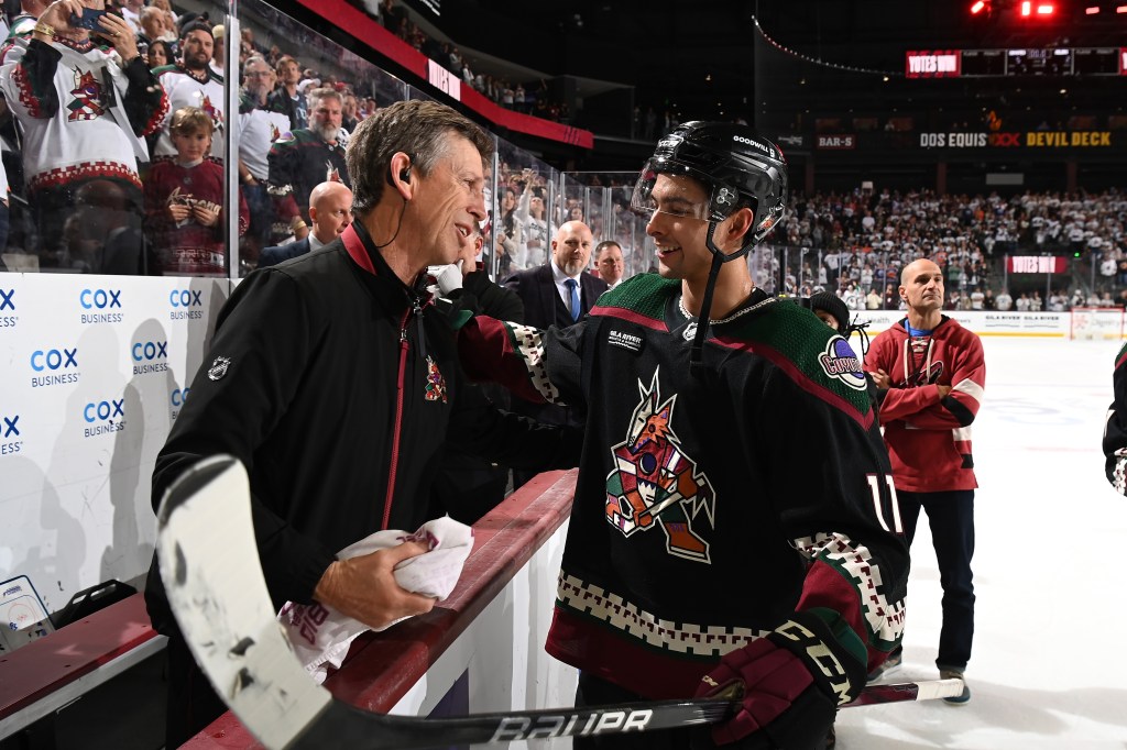 Dylan Guenther #11 of the Arizona Coyotes embraces Head Athletic Trainer Stan Wilson after a 5-2 win against the Edmonton Oilers at Mullett Arena on April 17, 2024 in Tempe, Arizona. 