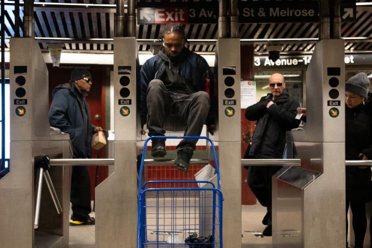 fare evaders jumping the turnstiles at an NYC subway station