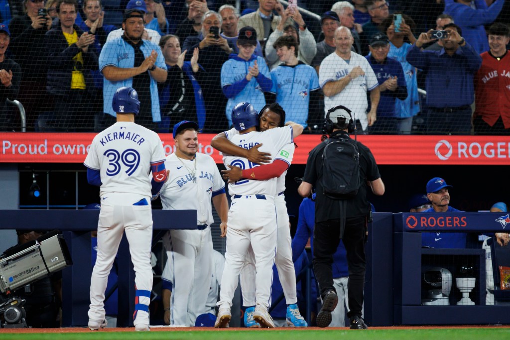 Daulton Varsho #25 of the Toronto Blue Jays gets a hug from Vladimir Guerrero Jr. #27 as he hits a solo home run in the seventh inning on Wednesday.