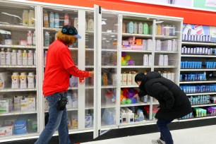 Retail store worker unlocking an anti-theft cabinet for a customer shopping for toiletries at a Target store in New York