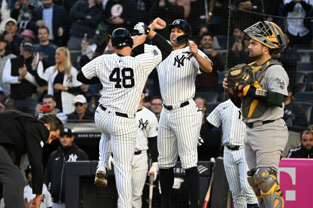 Anthony Rizzo (48) celebrates his home run with Yankees designated hitter Giancarlo Stanton in the first inning against the Oakland Athletics on Tuesday.