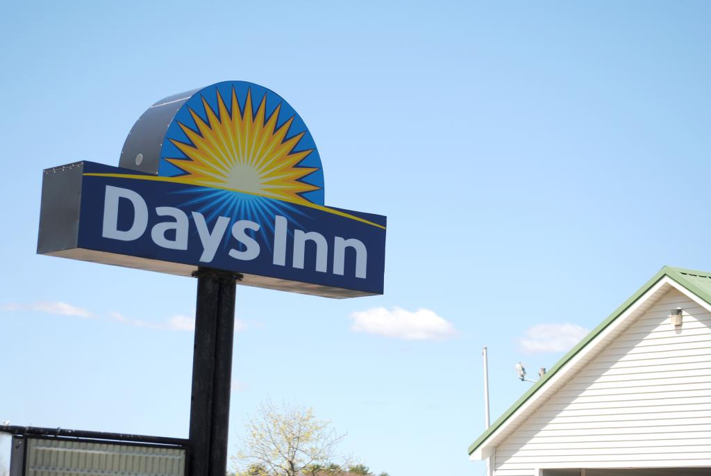 Days Inn road sign with a sun and a house in the background in Wells, Maine, symbolizing booming infrastructure projects.