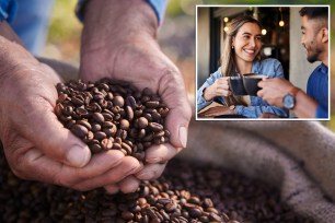 A person holding a handful of coffee beans