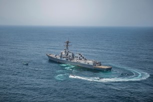 This photo made available Thursday, Aug. 28, 2018, a visit, board, search and seizure team from the guided-missile destroyer USS Jason Dunham (DDG 109) approach a skiff during maritime security operations. The stateless skiff was found carrying a shipment of over 1,000 illicit weapons. Dunham is deployed to the U.S. 5th Fleet area of operations in support of naval operations to ensure maritime stability and security in the Central Region, connecting the Mediterranean and the Pacific through the western Indian Ocean and three strategic choke points. (Mass Communication Specialist 3rd Class Jonathan Clay/U.S. Navy via AP)