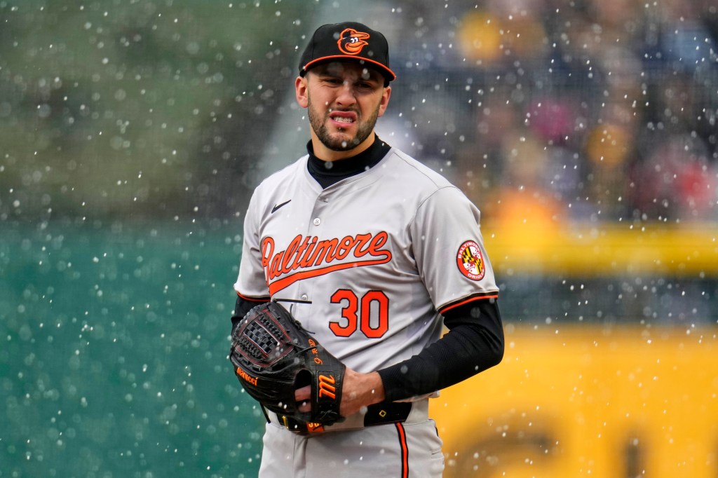 Baltimore Orioles pitcher Grayson Rodriguez prepares to deliver a pitch as snow falls during the second inning.