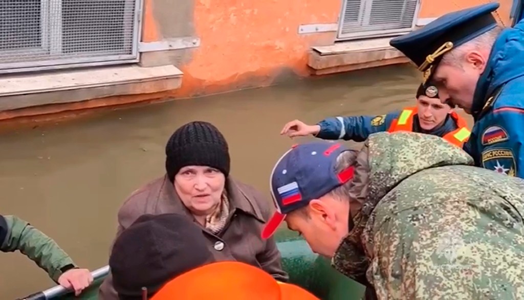 Russian Emergency Situations Minister Alexander Kurenkov speaking to a woman during the evacuation of residents and their pets due to a dam burst causing flooding in Orsk, Russia.