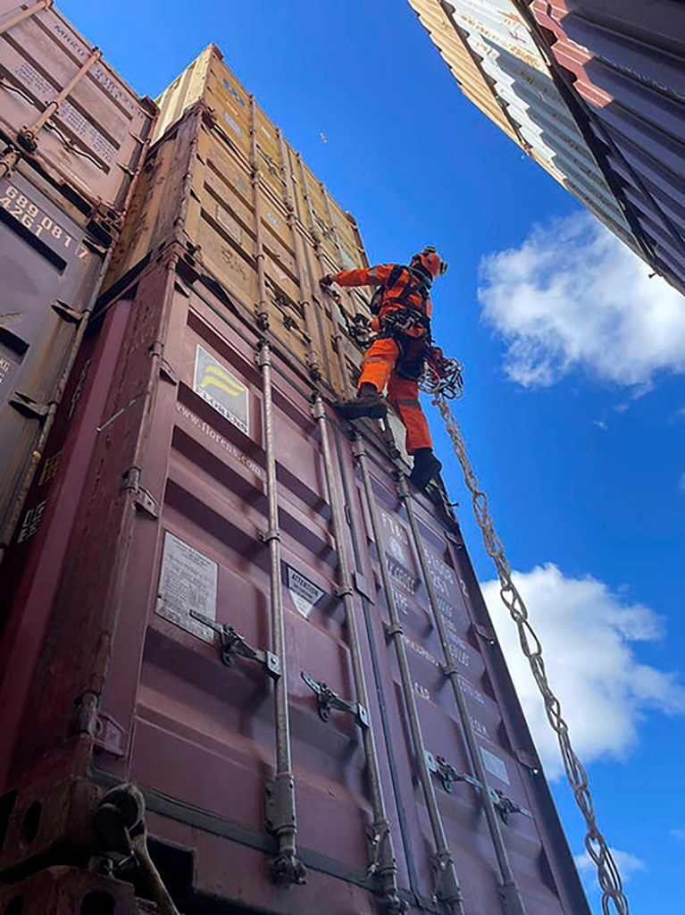 A specialized salvage climber scales a container to survey the damage to containers onboard the cargo ship Dali at the site of the Francis Scott Key Bridge on April 6, 2024, in Baltimore. 