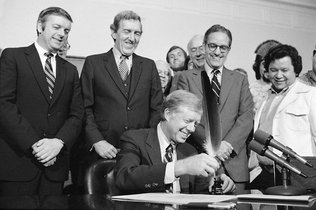President Jimmy Carter signs the Maine Indian Claims Settlement Act of 1980 at a ceremony at the White House with Maine Gov. Joseph Brennan, left, in attendance on Oct. 10, 1980.