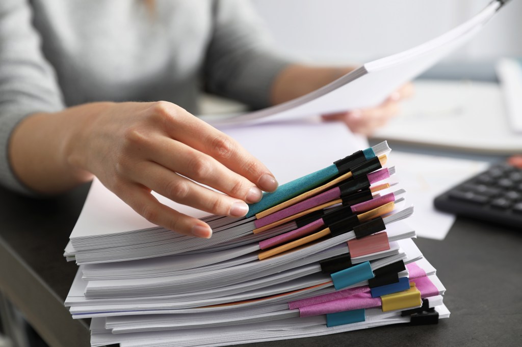 Office employee working with documents at table, closeup