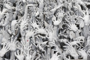 Vertical Photo of Abstract sculpture of reaching hands from Hell, evoking haunting atmosphere and desolation.