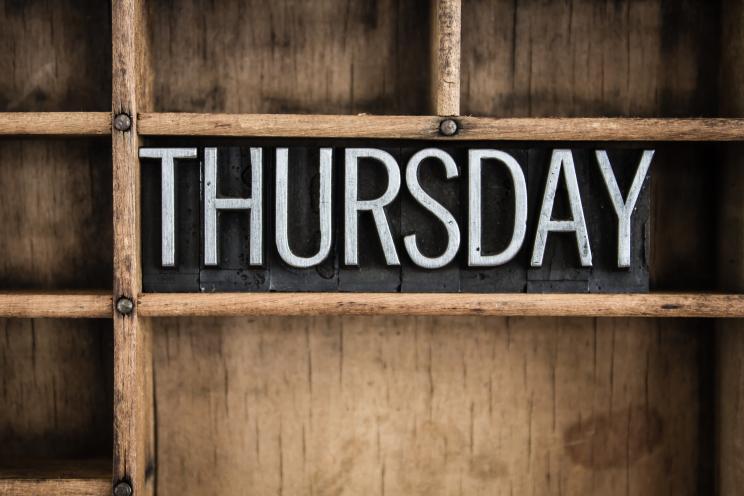 The word "THURSDAY" written in vintage metal letterpress type in a wooden drawer with dividers.